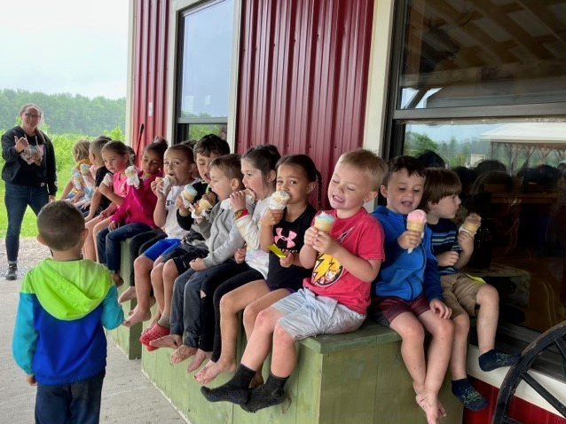 A large group of preschoolers eating ice cream